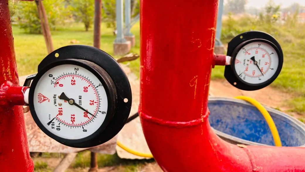 Two pressure gauges on red piping
